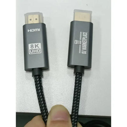 A close up of a person holding a black and white cable