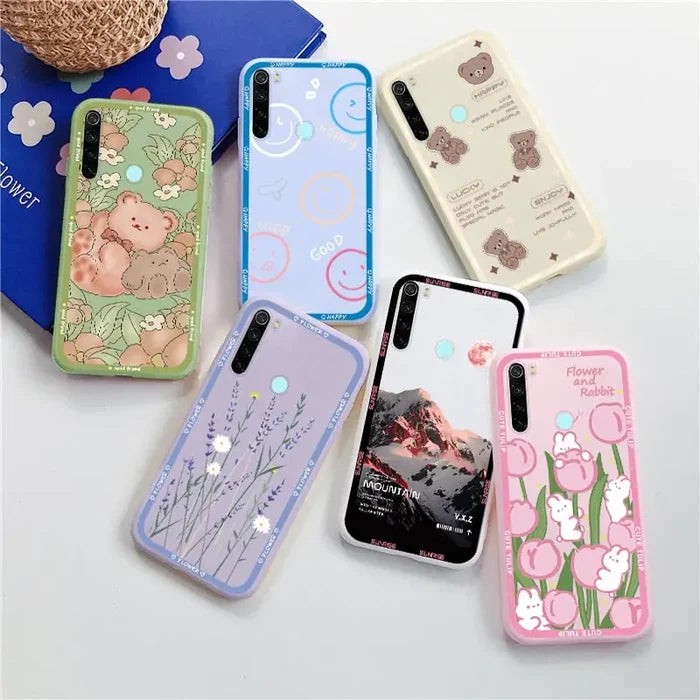 several different cases are arranged on a table with a teddy bear