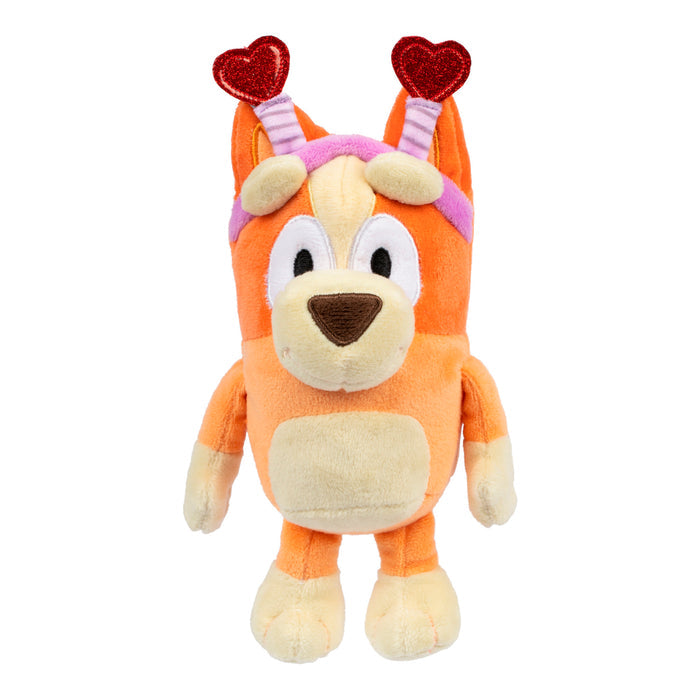 The Bluey & Friends Plushie by Moose Toys features an orange dog with a beige belly, pink headband, and red heart springs. With large eyes and upright stance, it's perfect for any Bluey stuffed animal fan!.