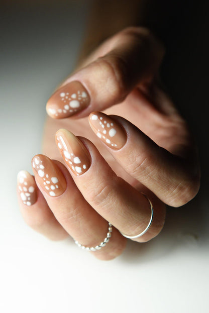 Caramel nude press-on nails with creamy white fawn spots – detail view