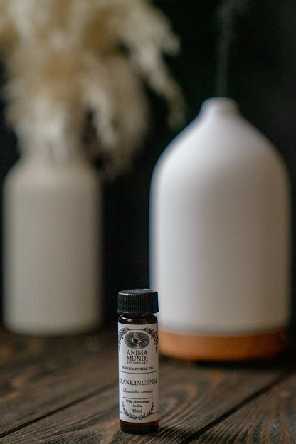 Small bottle of Anima Mundi on a wooden surface with white ceramic bottles in the background.