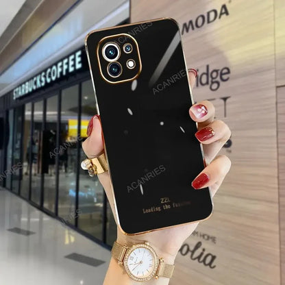 a woman holding up a black iphone case