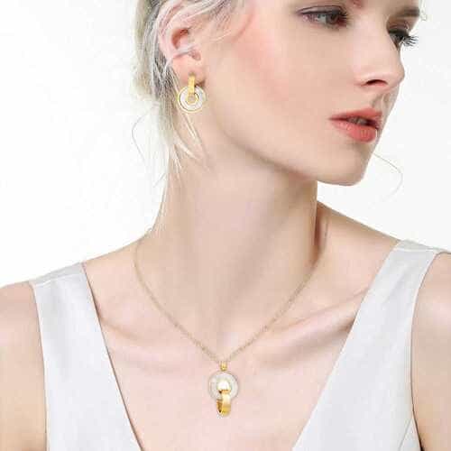 Woman wearing a gold necklace with a pendant on a white background