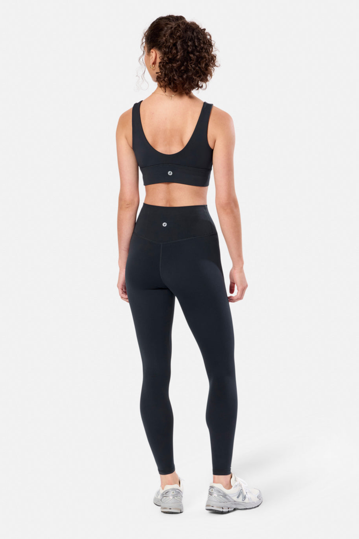 Woman wearing Gym + Coffee Soft-Motion Bra Black by Gym+Coffee with leggings, shop Gym+Coffee at Dotique for activewear.