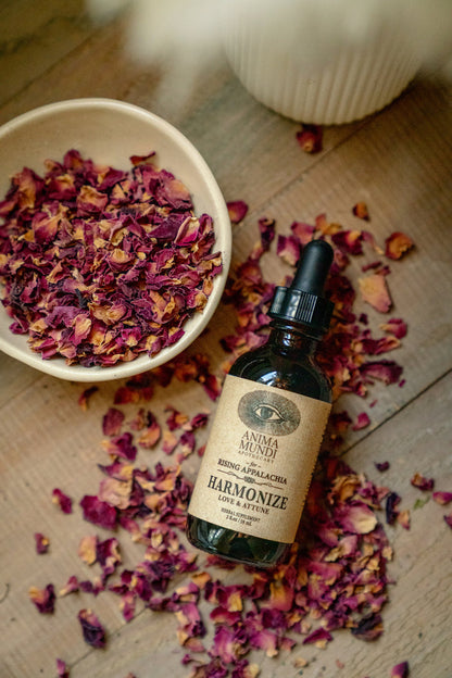 Bottle of 'Harmonize' with dried flowers on a wooden surface