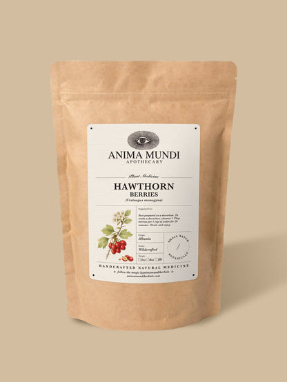 A kraft paper stand-up pouch of Anima Mundi Apothecary Hawthorn Berries, featuring a white label with botanical illustrations of the berries, set against a solid beige background.