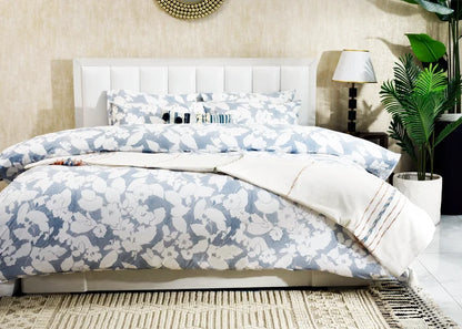 Blue and white botanical duvet cover set on bed with coordinating pillowcases