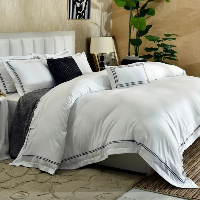 White duvet cover set with black piped trim and dark navy textured pillows