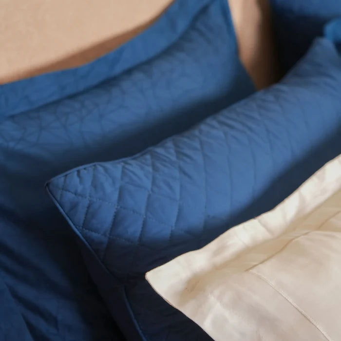 Blue cotton sateen duvet cover with quilted pattern, folded corner visible