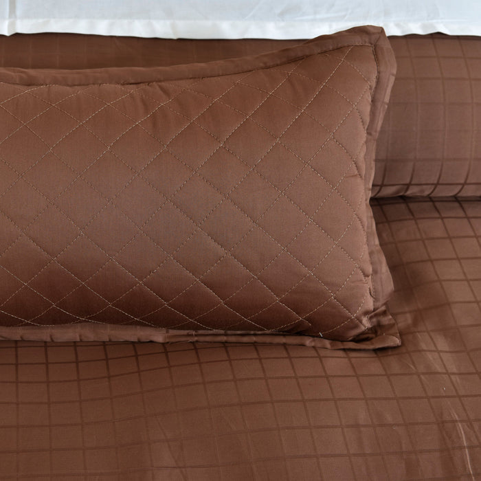 Brown quilted pillow with diamond stitching on matching duvet cover