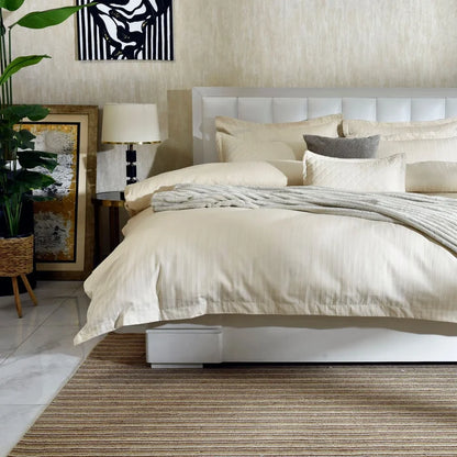 Cream 7-piece duvet cover set on bed with quilted pillows and matching accents