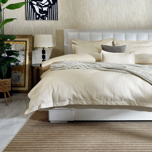Cream 7-piece duvet cover set on bed with quilted pillows and matching accents