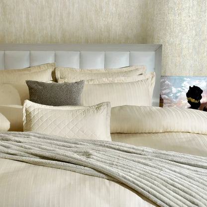 Cream duvet cover set on bed with quilted panel and matching striped accents