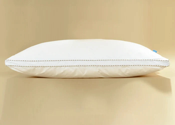 White filled pillow side view with piped edge and stitched border