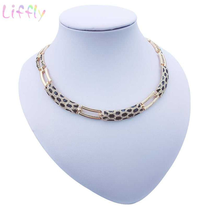 Luxury bridal gold jewelry set featuring geometric design with crystals. Includes necklace, earrings, bracelet and ring. Ideal for weddings and parties.