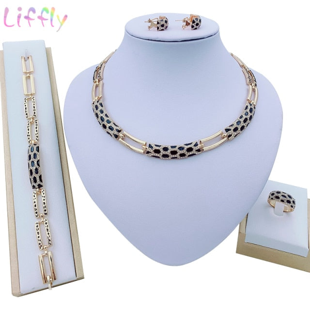 Luxury bridal gold jewelry set featuring geometric design with crystals. Includes necklace, earrings, bracelet and ring. Ideal for weddings and parties.