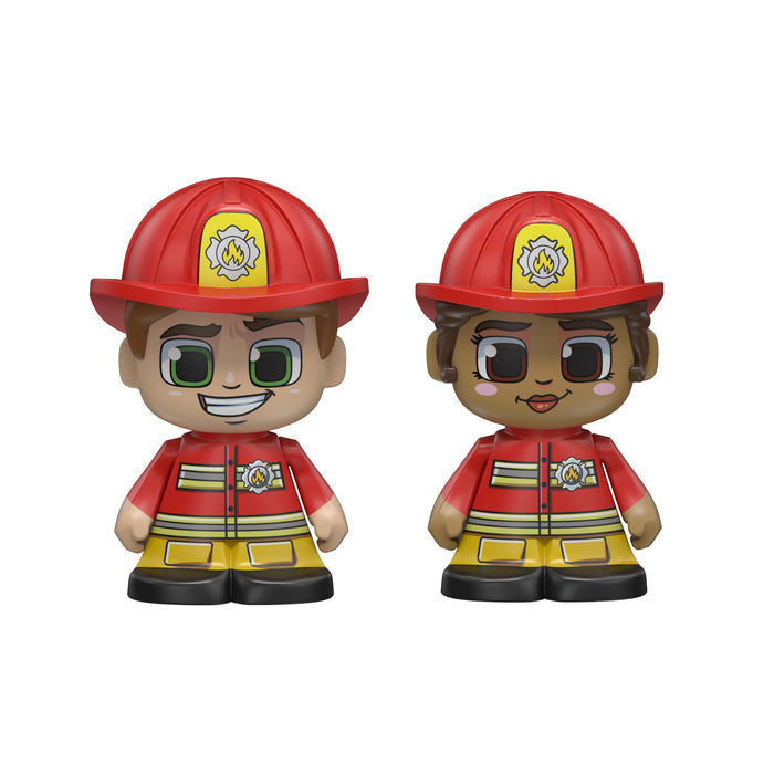 Two cartoon firefighter figures from Moose Toys Tile Town Fire Station Tile Set stand side by side, wearing red helmets and jackets with yellow pants. One has light skin and green eyes; the other, medium skin and brown eyes.