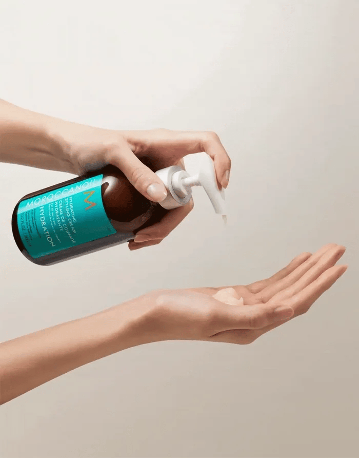 Moroccanoil Hydrating Styling Cream hand pumping cream out