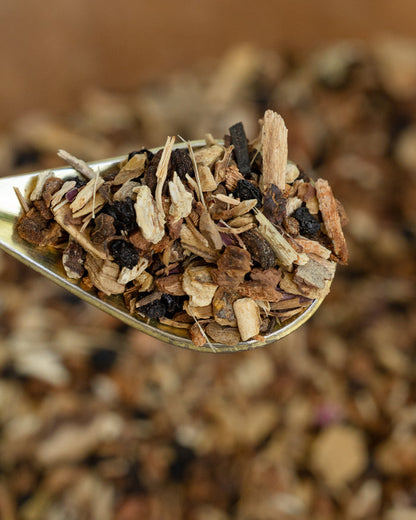 Spoonful of dried herbs and spices against a blurred natural background