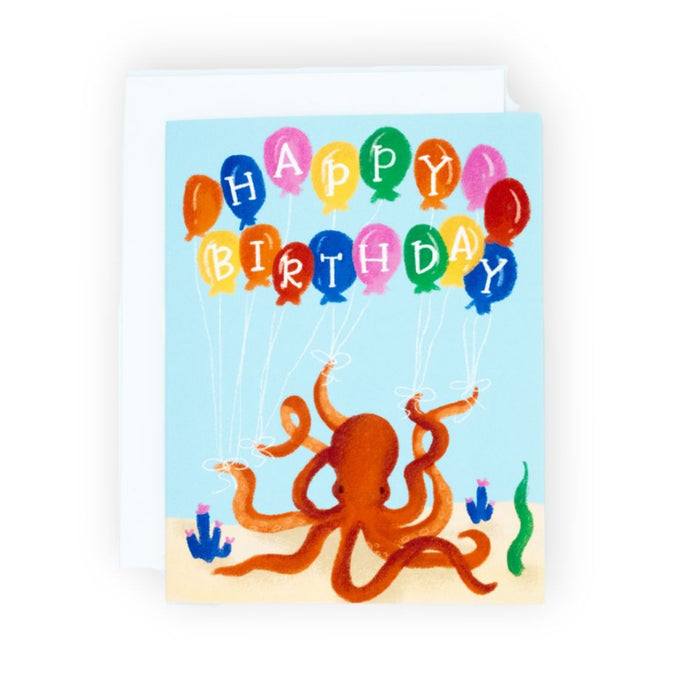Birthday card with red octopus on sand holding balloon strings spelling Happy Birthday against an ocean floor