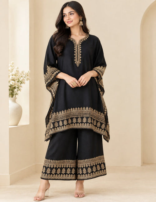 Model posing in an elegant black kaftan and palazzo set with detailed gold foil printing and embroidery against a neutral background.