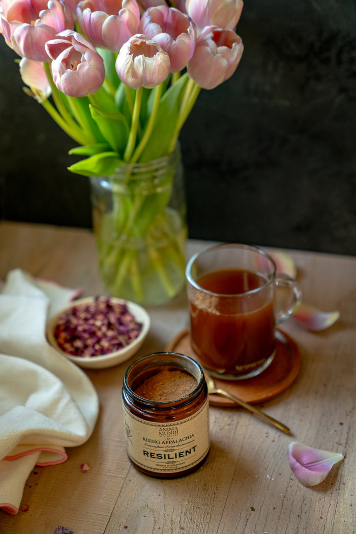 Tea, jar of honey, and pink tulips on a wooden table