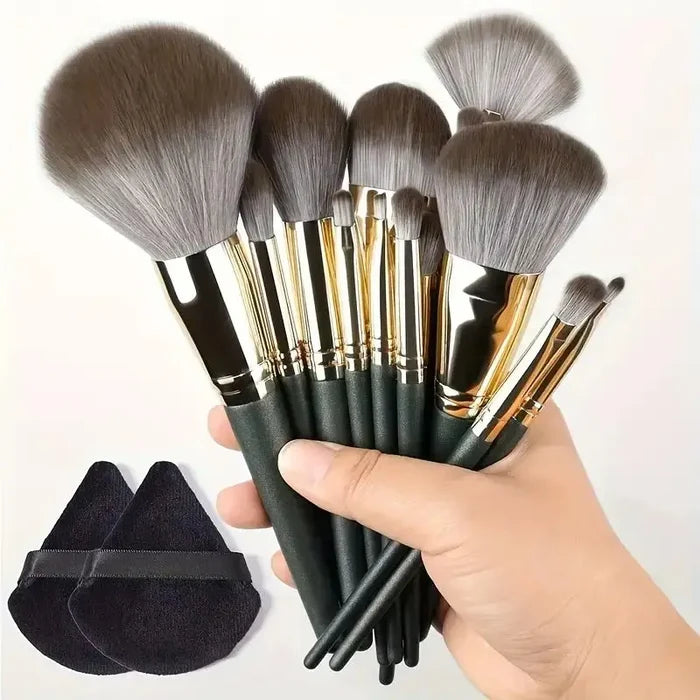 Set of makeup brushes with black handles and gold accents held by a hand, with a black brush holder on a white background. Soft fluffy makeup brush set with wool fiber bristles and plastic handles. Complete set for powder, foundation, eyeshadow, and beauty blending.