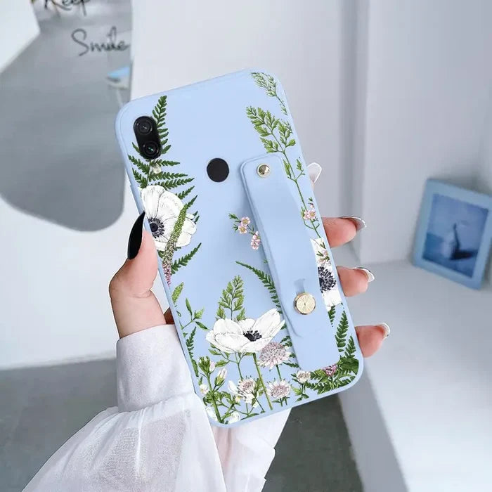 a woman holding a phone case with flowers on it