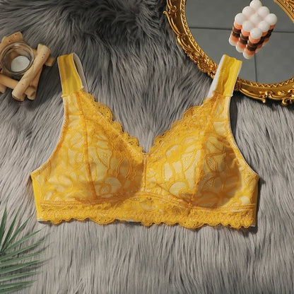 Yellow lace bra on a textured surface with decorative elements.