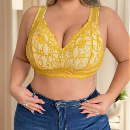 Yellow lace bra worn with blue jeans against a neutral background