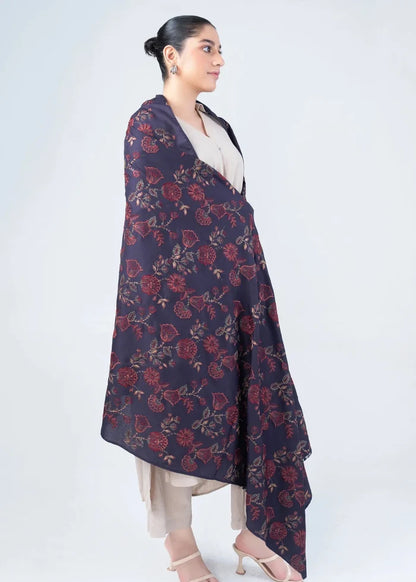 Women's wool winter shawl in dark navy with burgundy floral pattern, worn over beige outfit
