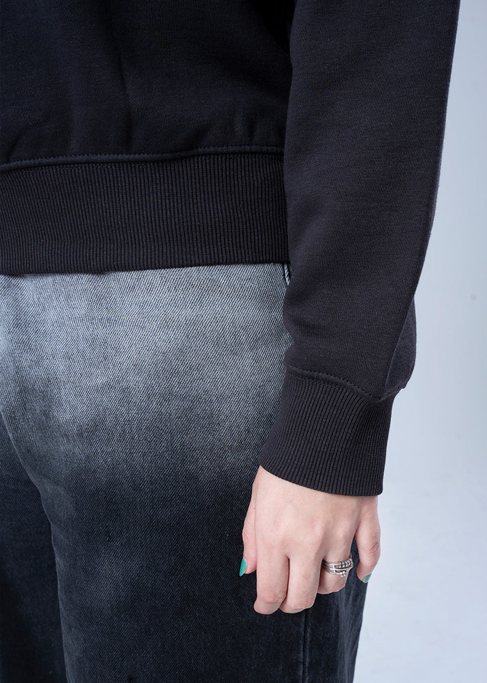 Black sweatshirt cuff and hem with ribbed finish, hand wearing ring