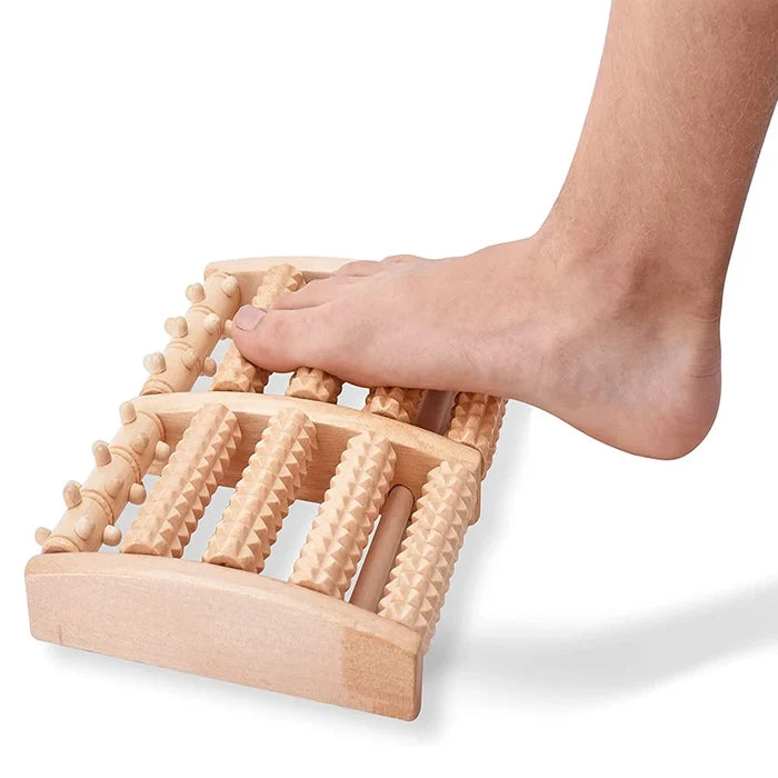 Wooden foot massager being used on a foot against a white background
